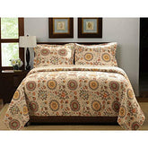A bed featuring a delicate floral pattern, with various flowers in bright colors decorating the comforter.